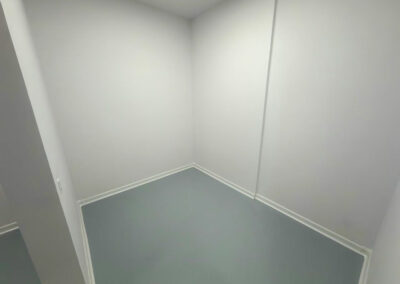 Inside corner of a white room with a white cove base along a gray floor